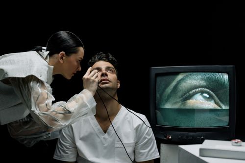 Free Technician performing eye exam using advanced medical technology with real-time monitoring. Stock Photo