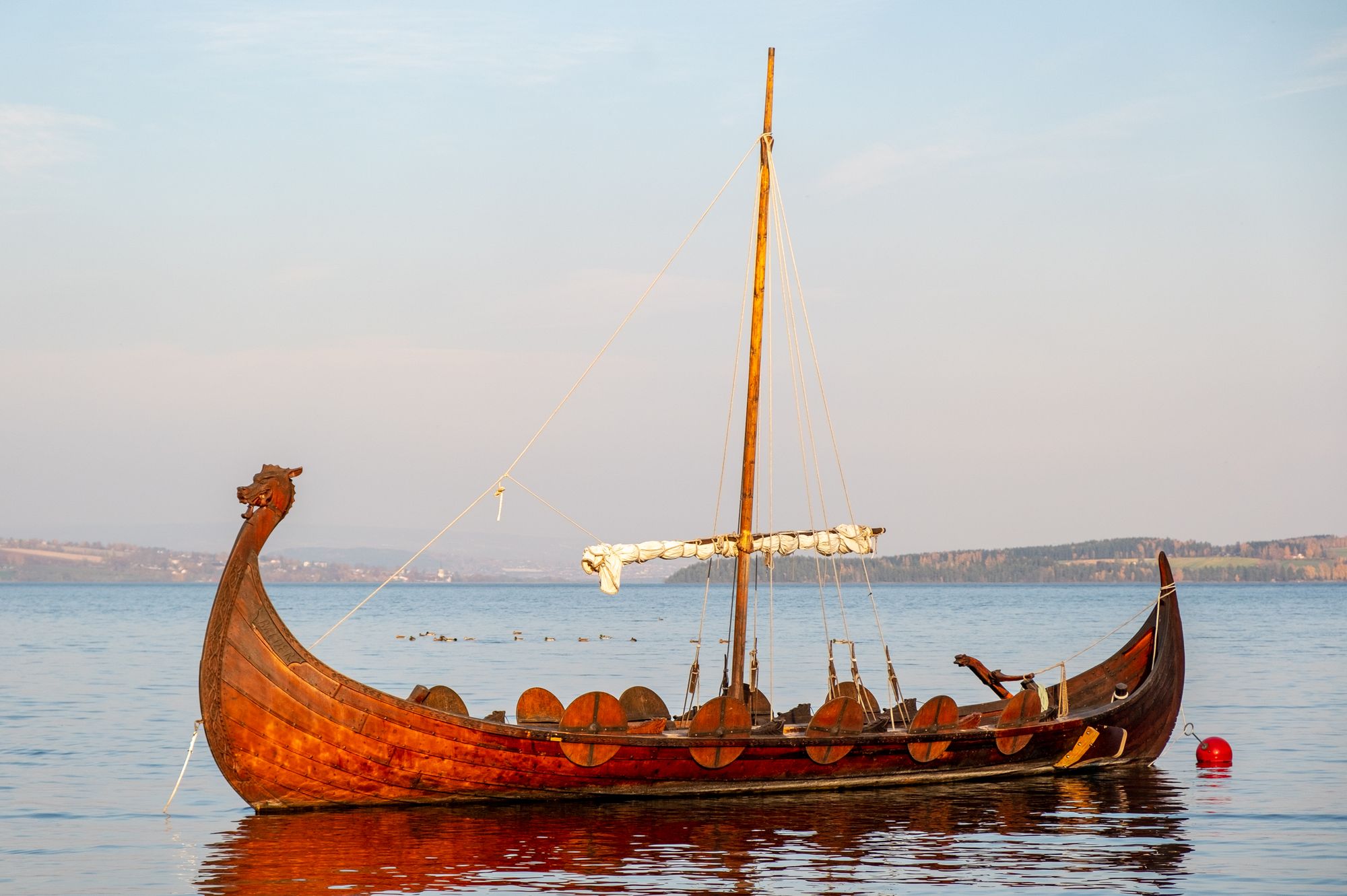 Réplica de un barco vikingo navegando en mar abierto bajo un cielo nublado
