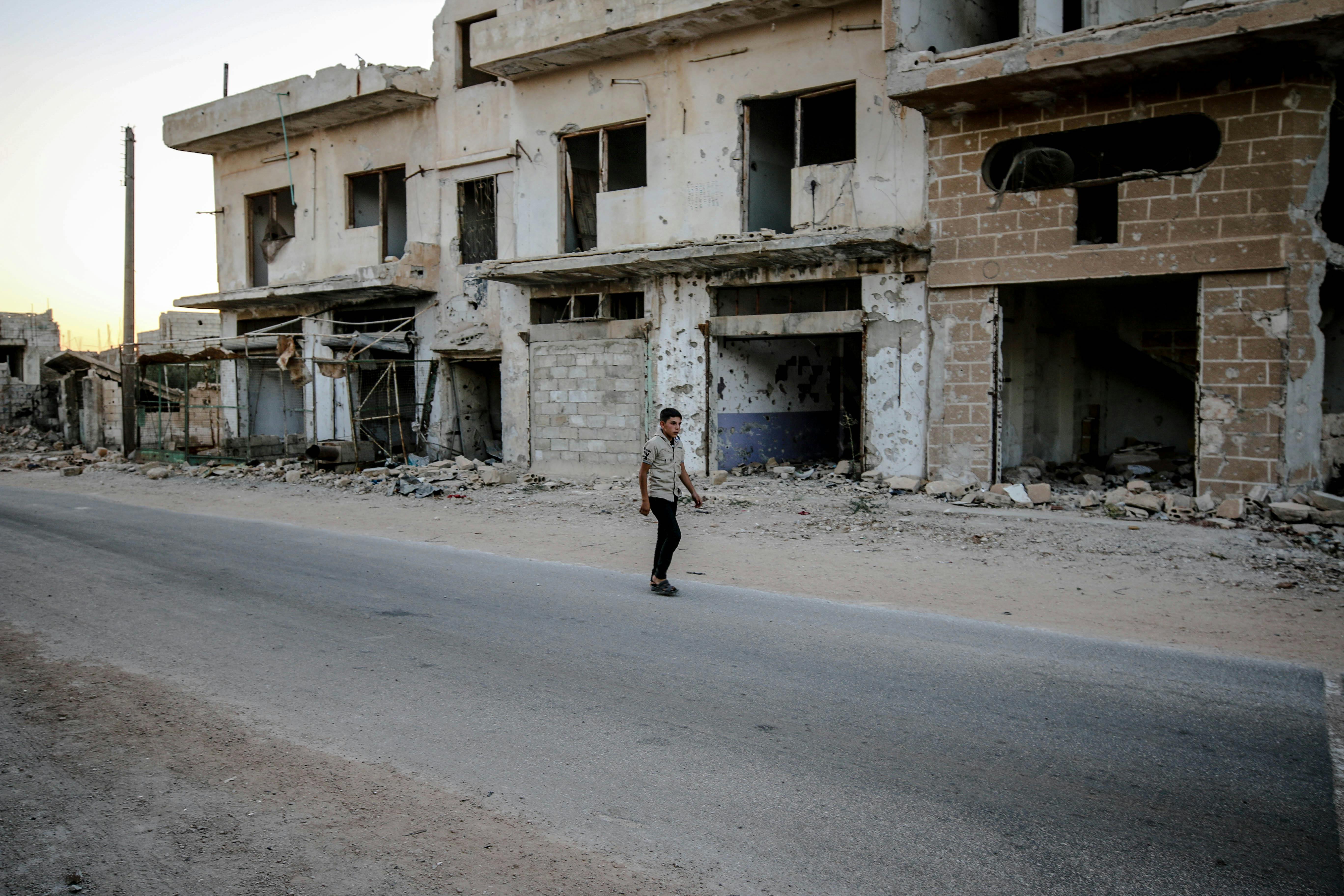 Man Walking by Abandoned Houses After an Earthquake · Free Stock Photo