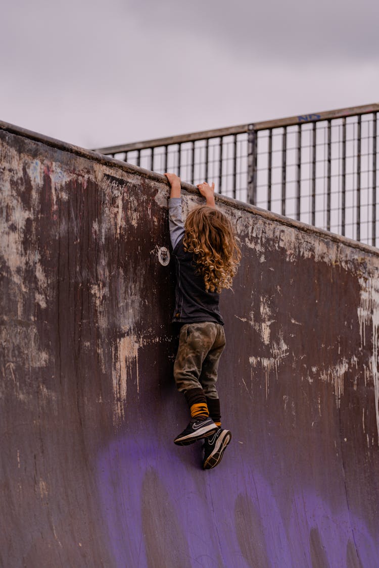 Child Hanging On Skatepark Ramp