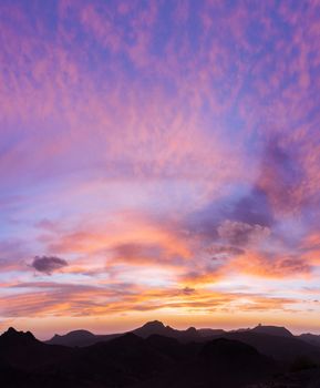 Breathtaking sunset over Tamanrasset's mountains with vibrant colors filling the sky.