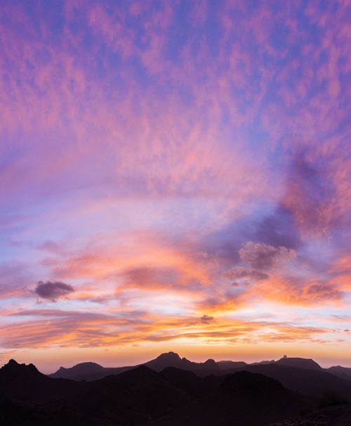 Free Breathtaking sunset over Tamanrasset's mountains with vibrant colors filling the sky. Stock Photo