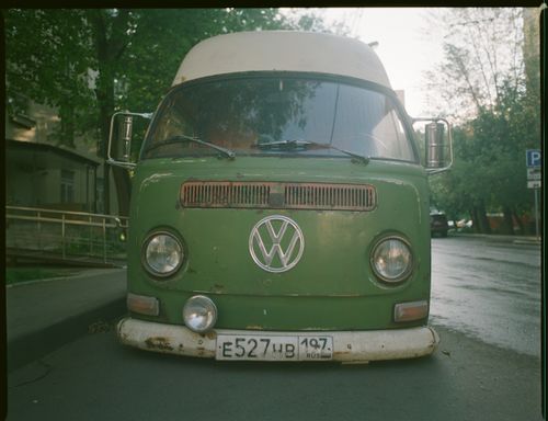 Free A front-facing vintage green Volkswagen van parked on a quiet street. Stock Photo