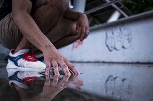 Photo of a Person's Hand Touching the Water