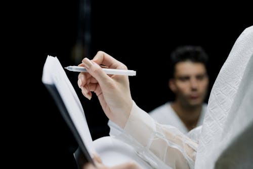 Free Person Holding a Pen and Notebook Stock Photo
