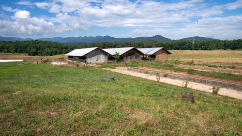 Free Explore a tranquil rural scene with barns, grasslands, and scenic mountain views in North Carolina. Stock Photo