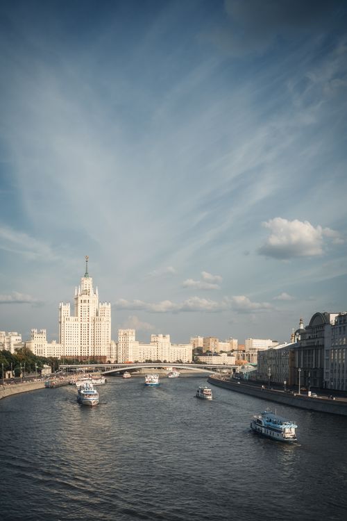 Free Scenic view of Moscow's river with boats against the Kotelnicheskaya Embankment Building. Stock Photo