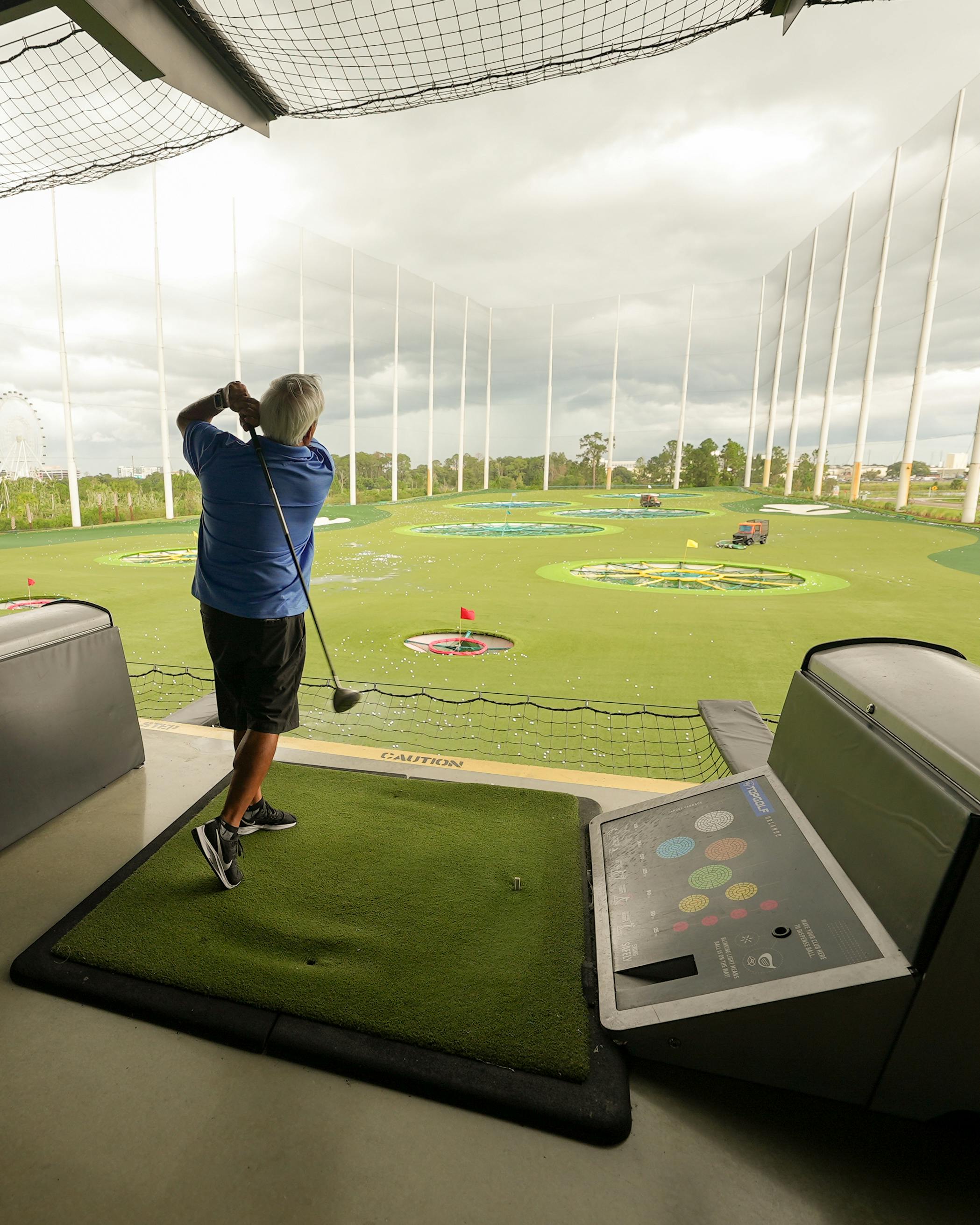 elderly man in blue polo shirt playing golf