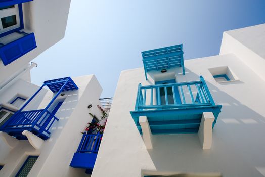 在晴朗的天空下，白色建筑设有充满活力的蓝色阳台，非常适合建筑主题