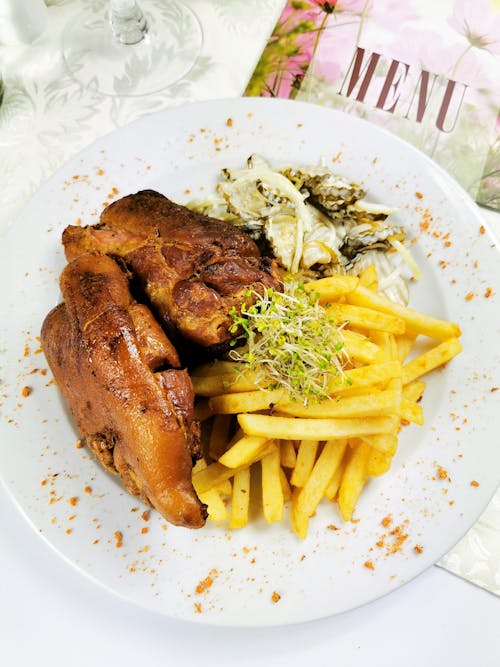 Free Chicken Barbecue with Potatoes and Salad on White Ceramic Plate Stock Photo