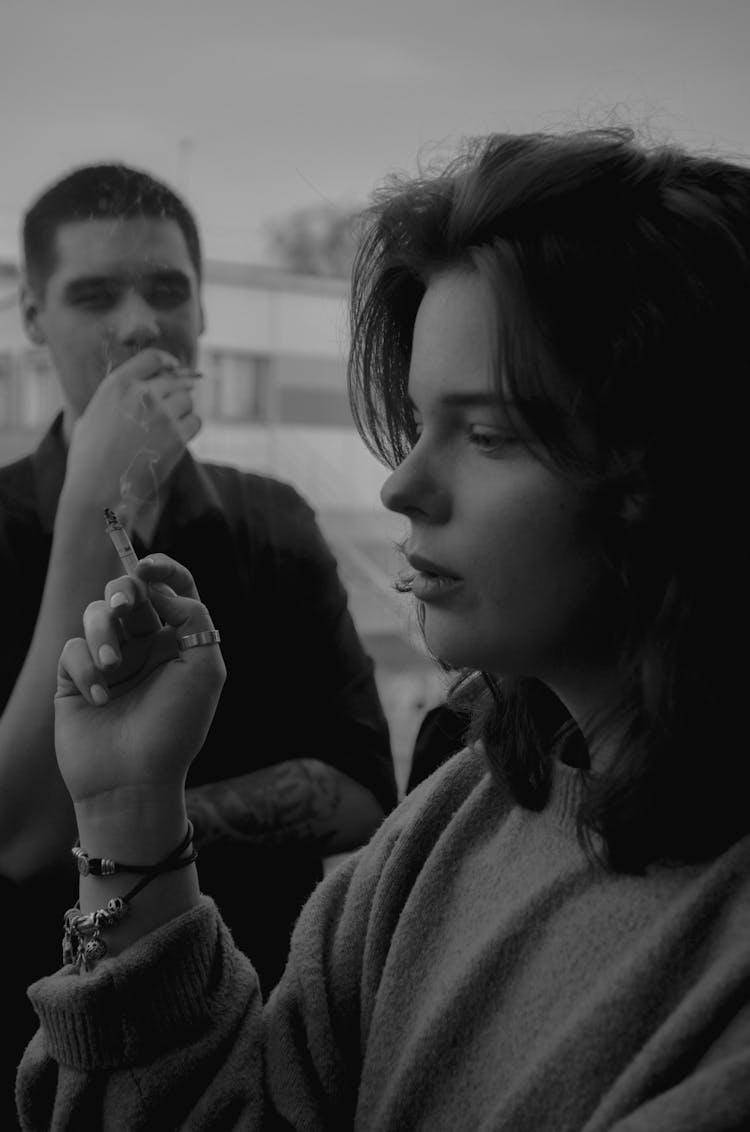 A Man And A Woman Smoking Cigarettes