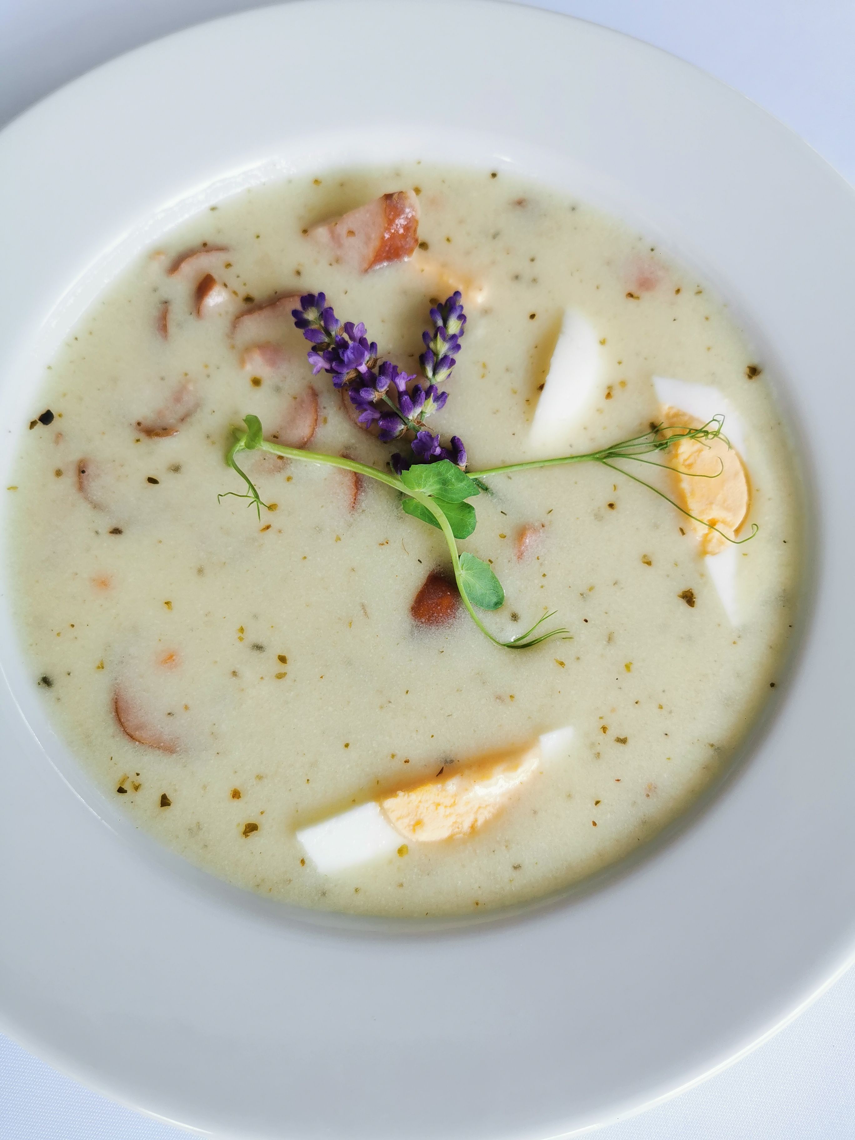 A traditional Polish sour rye soup made with fermented rye starter, smoked sausage, and a soft-boiled egg.