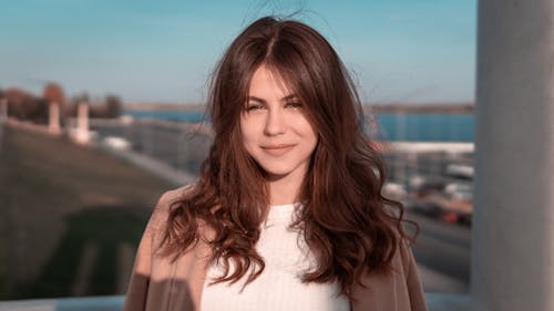 Portrait of a Smiling Woman in White Shirt with Brown Coat