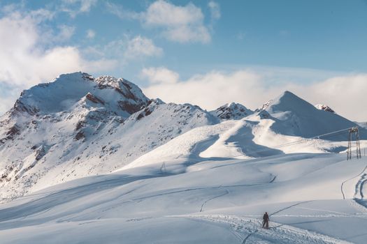 一名孤独的徒步旅行者在晴朗的天空下穿越雪山