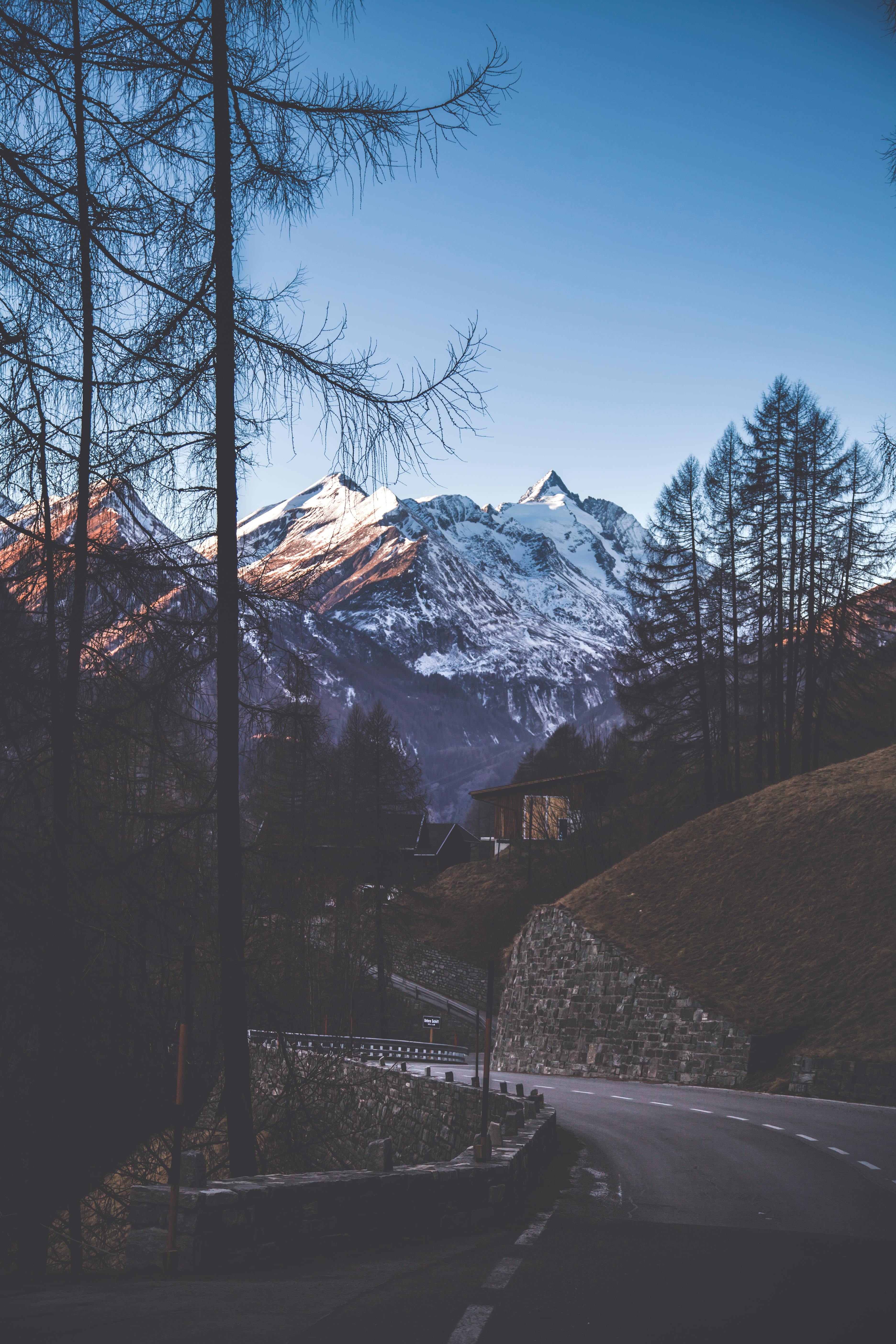 Prescription Goggle Inserts - A picturesque mountain road leading to a snow-covered peak under a clear winter sky.