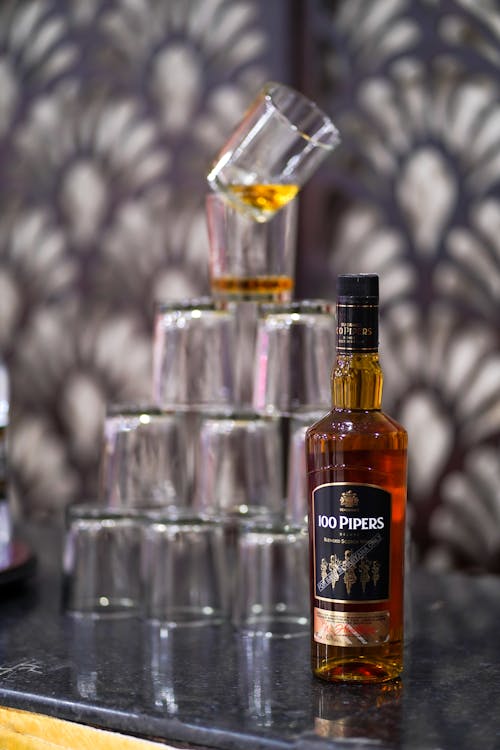 A Bottle of Scotch and Stacked Glasses