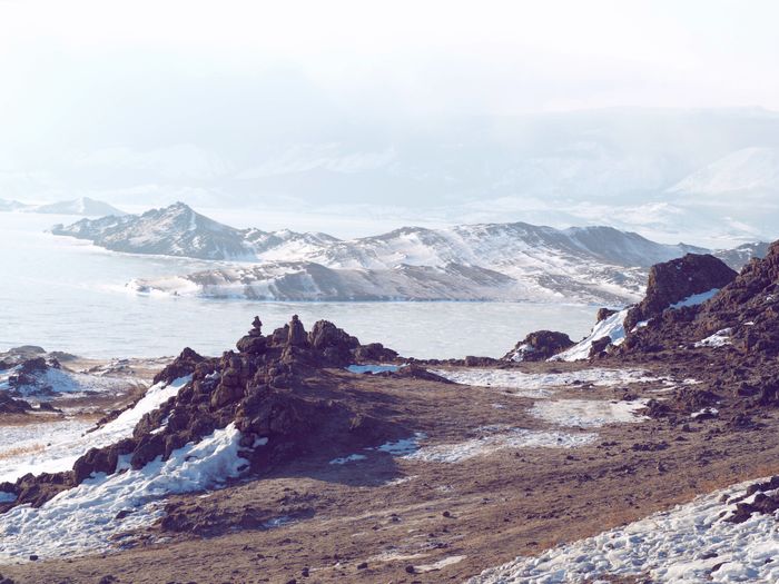 Scenic view of snow-covered mountains and a frozen sea in Apatity, Russia., by Katerina Zaytseva on Pexels