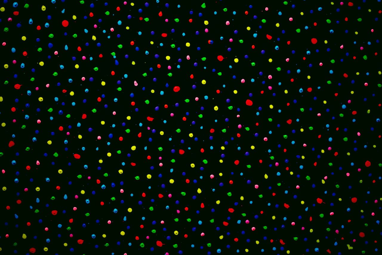 vibrant abstract art with colorful dots scattered across a black backg
