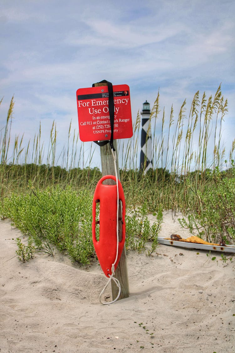 An Emergency Rescue Tube On A Wooden Post