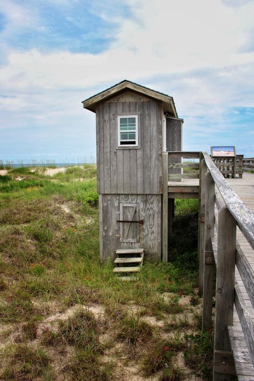 Free A vertical shot of a wooden cabin by the seashore with a bridge trail. Stock Photo