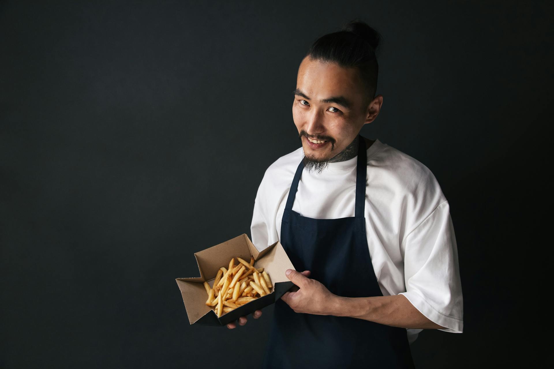 Photo of a Chef Holding a Food Container with French Fries