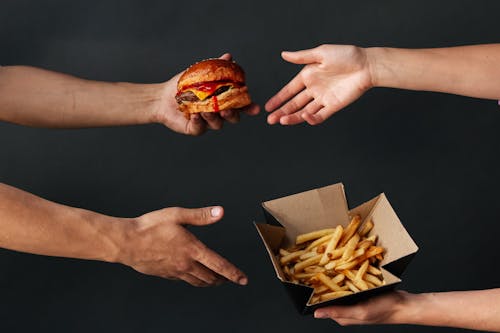 Two Persons Exchanging Foods