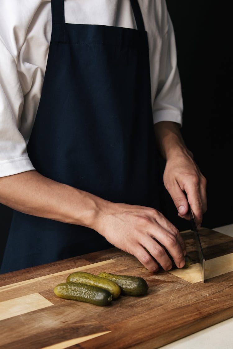 A Chef Cutting Pickled Cucumbers