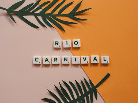Flat lay of 'Rio Carnival' spelled with Scrabble tiles on a vibrant yellow and pink surface with tropical leaves.
