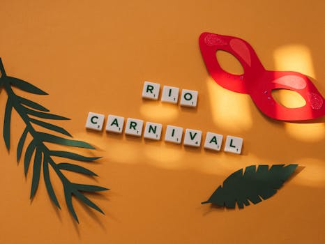 Festive Rio Carnival scene with letter tiles, paper mask, and tropical leaves on a vibrant yellow surface.
