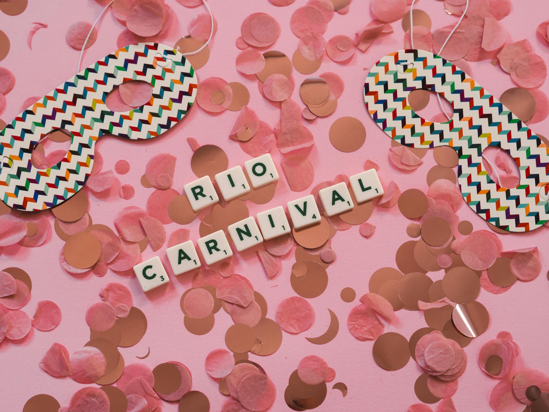 Colorful carnival masks and confetti celebrate the Rio Carnival on a pink background.