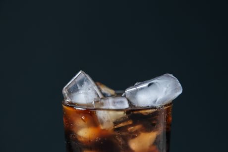 Close-up of a fizzy dark soda with ice cubes — photo by Ron Lach on Pexels