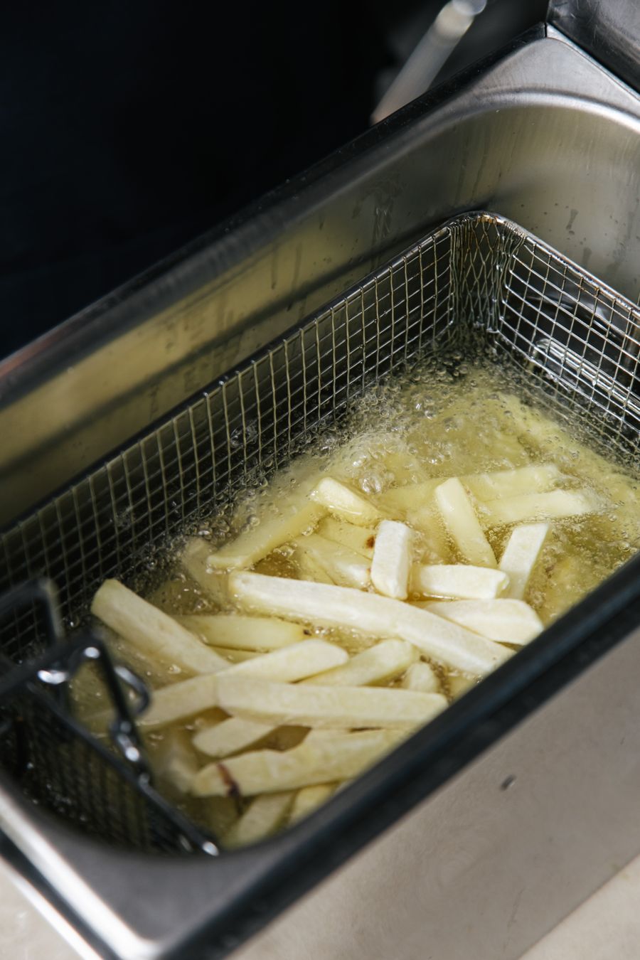 French fries cooking in a commercial deep fryer