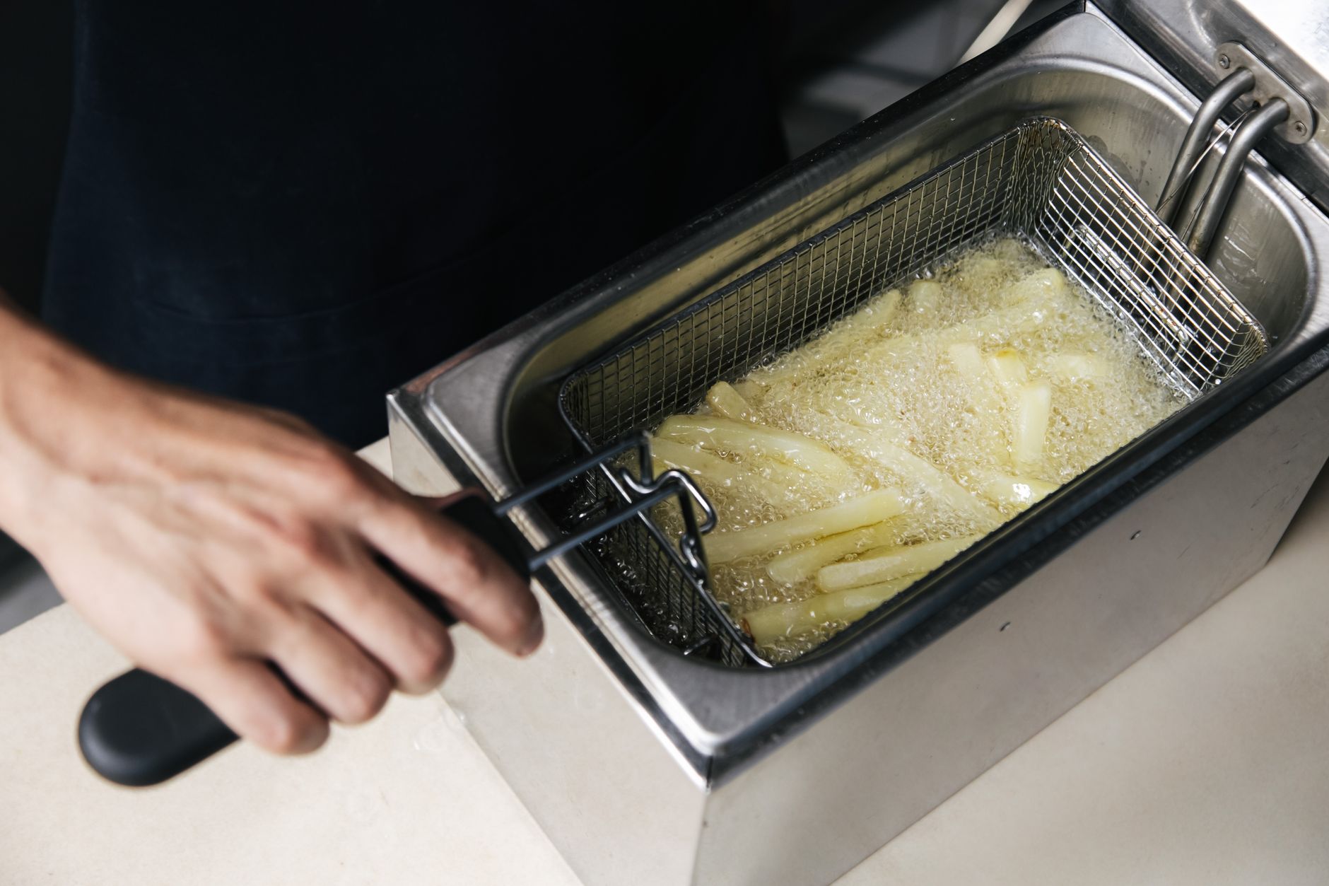 Close-up frying leftover french fries in a hot skillet to crisp them up