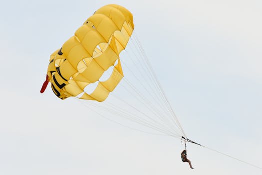 Enjoy the thrill of parasailing over Cape May with a bright yellow parachute soaring through the sky.