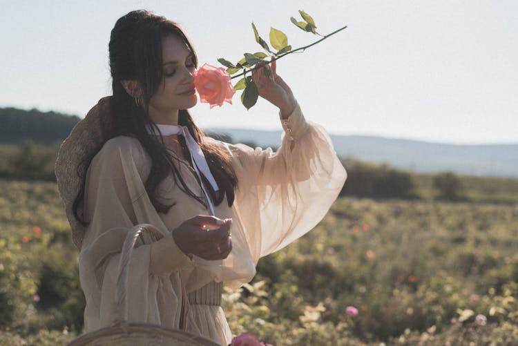 Woman Smelling A Rose