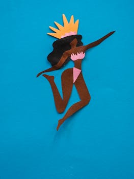 Colorful paper cutout of a dancer on a vibrant blue background, capturing festive vibes.