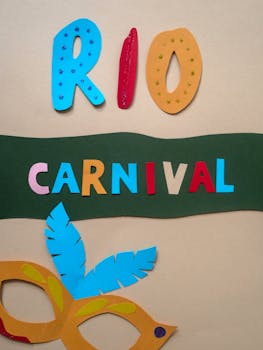A vibrant paper art composition featuring text 'Rio Carnival' with a decorative mask.