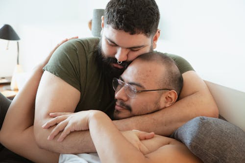 Free Photo of a Man with Facial Hair Hugging a Man with Eyeglasses Stock Photo