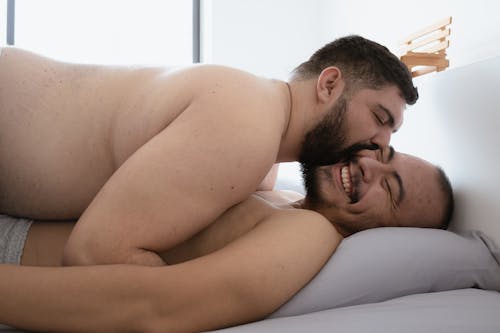 Shirtless Men Lying on Bed