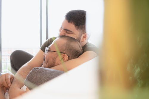 Free Two Men Sitting on a Couch Showing Love and Affection Stock Photo