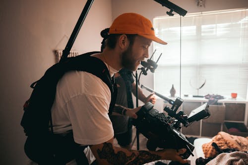 Man Holding a Video Camera Filming Inside a Room