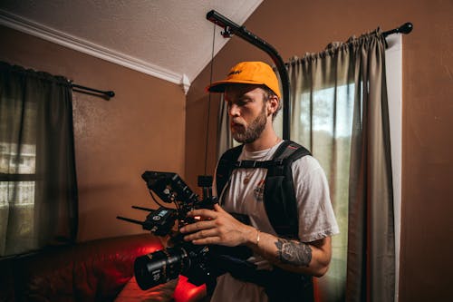 Photo of a Videographer Wearing a Yellow Cap