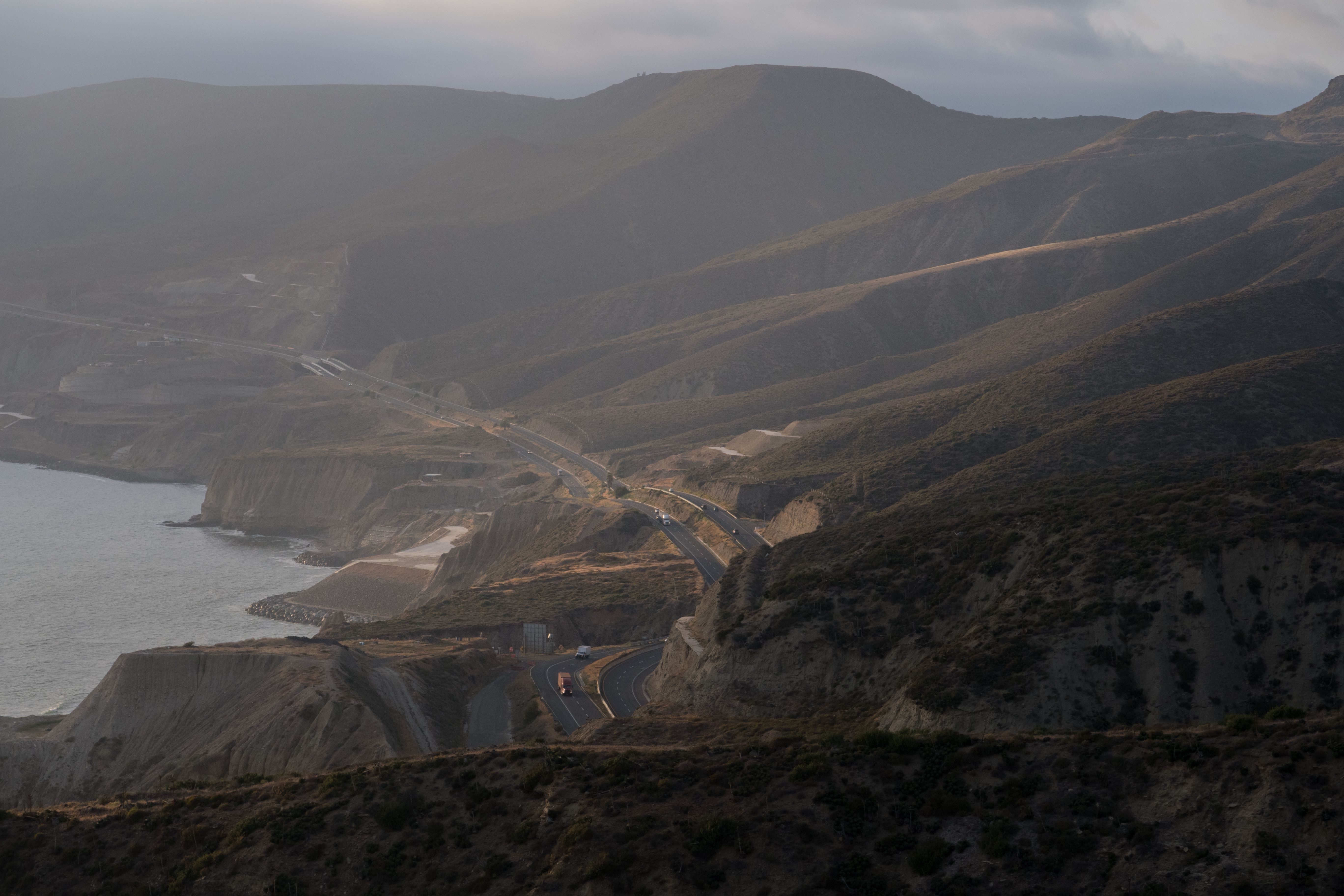 Dramatic aerial view of winding coastal roads through Guadalupe's hills at dusk. Dramatic aerial view of winding coastal roads through Guadalupe's hills at dusk.