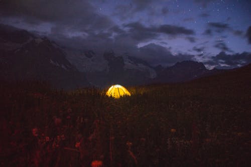 Yellow Tent on a Grass Field During Night Time