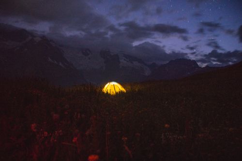 Free A glowing tent under a starry night sky in the scenic Caucasus Mountains, creating a serene outdoor camping experience. Stock Photo