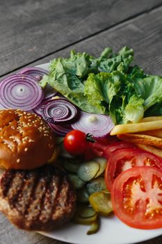 An appetizing display of burger ingredients including buns, patties, and fresh vegetables.