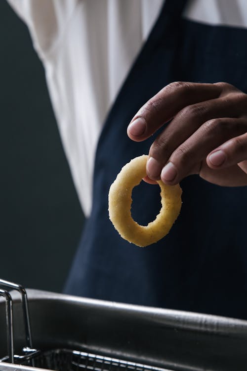 Free Person Holding an Onion Ring Stock Photo