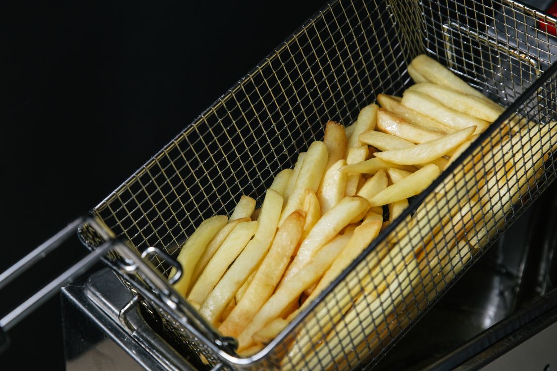 Crispy french fries in a metal basket.