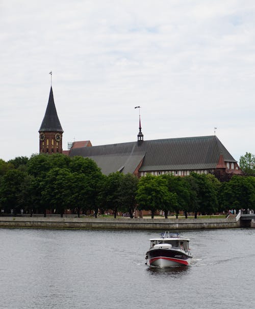 Free Photo of Boat on River Near the Konisberg Cathedral in Russia Stock Photo