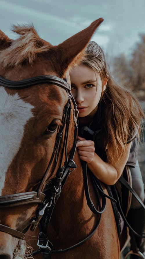 Free Woman Looking at Camera With a Horse Stock Photo